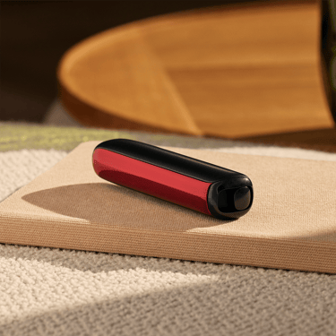 Painel Frontal Lava Red no dispositivo Ploom AURA, colocado sobre uma mesa