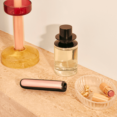 Painéis frontais Rose Gold com padrão brilhante para Ploom AURA colocados numa mesa de maquilhagem