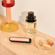 Painéis frontais Rose Gold com padrão brilhante para Ploom AURA colocados numa mesa de maquilhagem