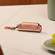 Estojo individual em couro sintético Rose Gold para Ploom AURA sobre uma mesa