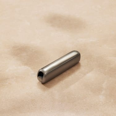 Plano aproximado de um painel frontal Lunar Silver para Ploom AURA numa superfície plana