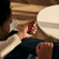 Uma mão a segurar o dispositivo Ploom AURA com um painel frontal Lava Red. 