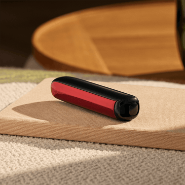 Painel Frontal Lava Red no dispositivo Ploom AURA, colocado sobre uma mesa
