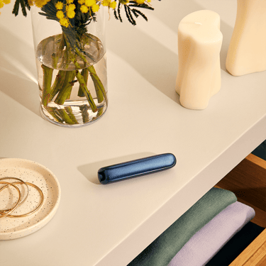 Painel Frontal Navy Blue padrão brilhante no dispositivo Ploom AURA, colocado sobre uma mesa