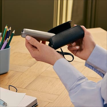 Estojo individual em couro Saffiano Jet Black para Ploom AURA sobre uma mesa