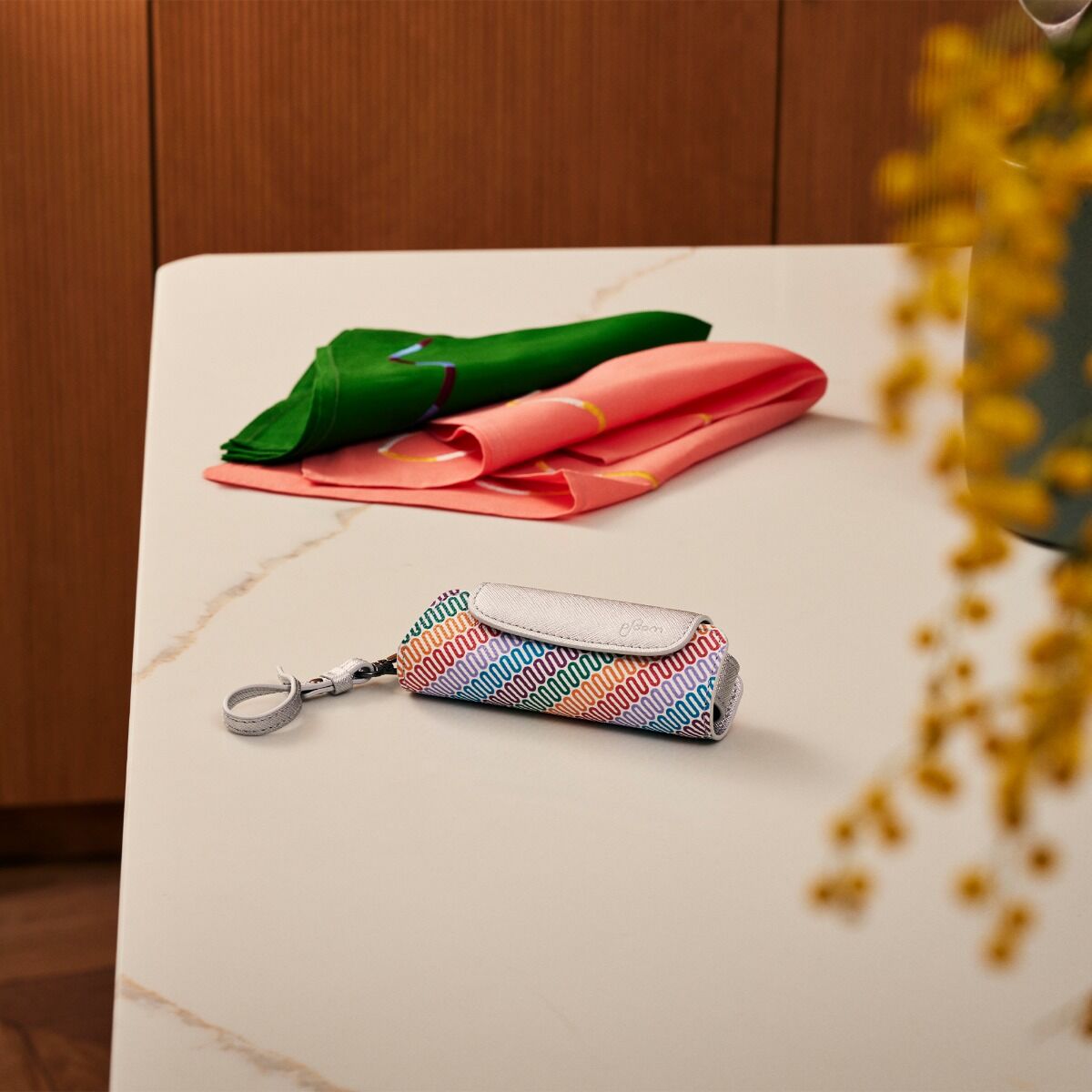 Estojo Individual em tecido multicolorido e couro Silver sobre uma mesa