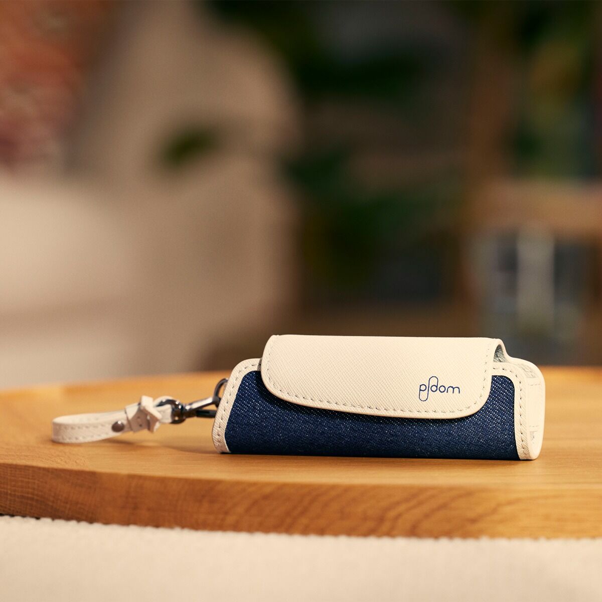 Estojo individual em ganga e couro Grey para Ploom AURA sobre uma mesa 